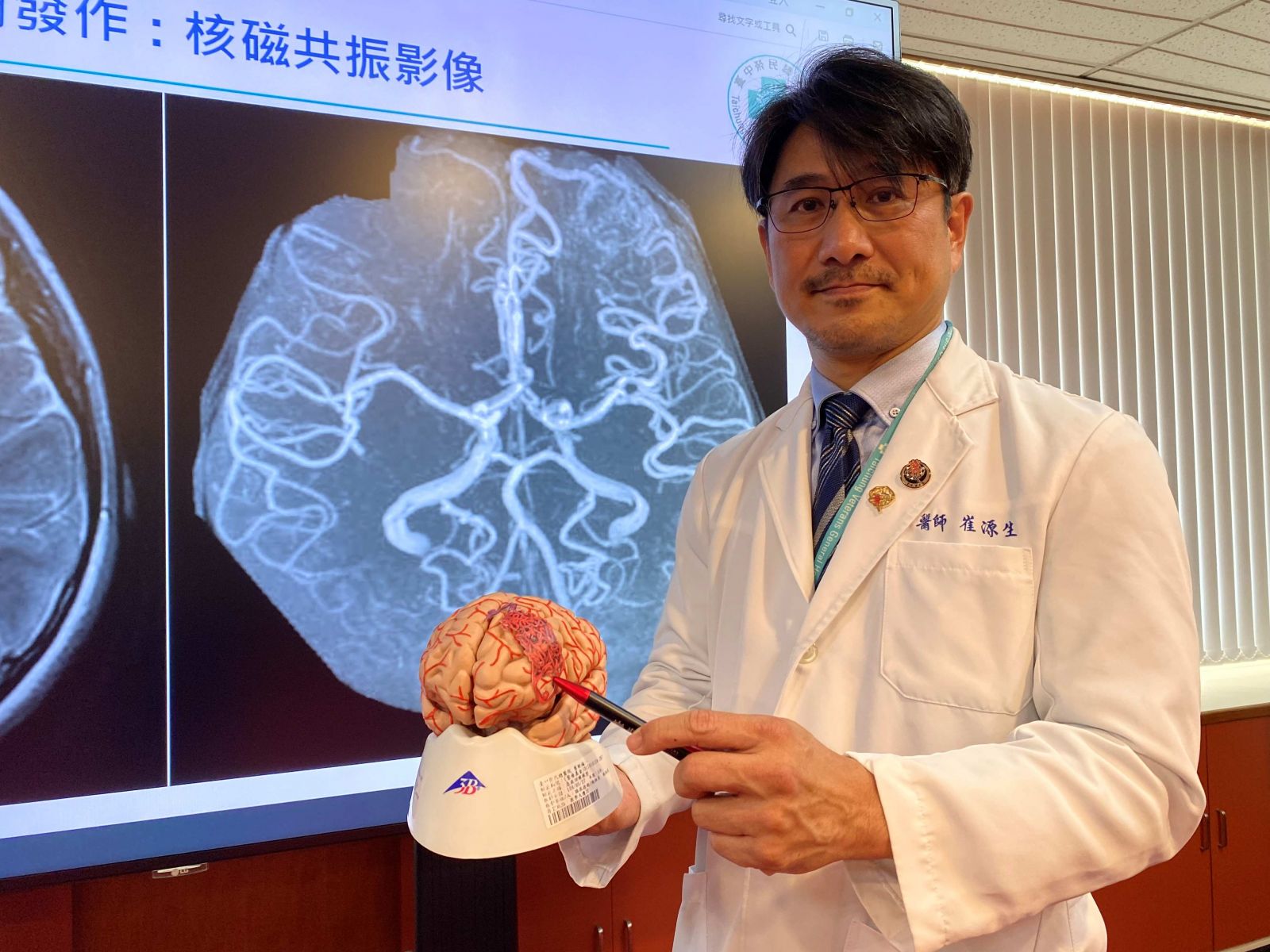 圖：臺中榮總神經醫學中心介入性腦血管外科主任崔源生，解釋劉小妹的腦動靜脈畸形在左額葉／臺中榮總提供